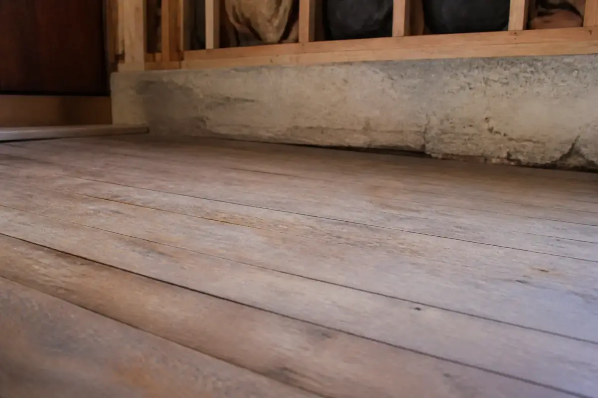 Slightly sloping wood floor near a foundation wall
